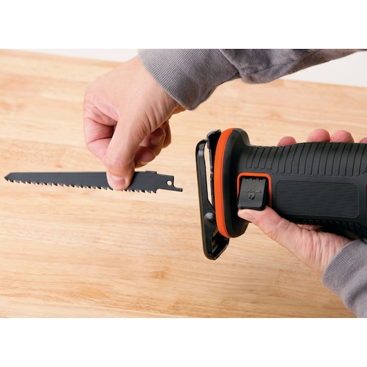 Photo de la scie réciproque BLACKDECKER BDCR20C avec un utilisateur installant la lame sur une surface en bois.