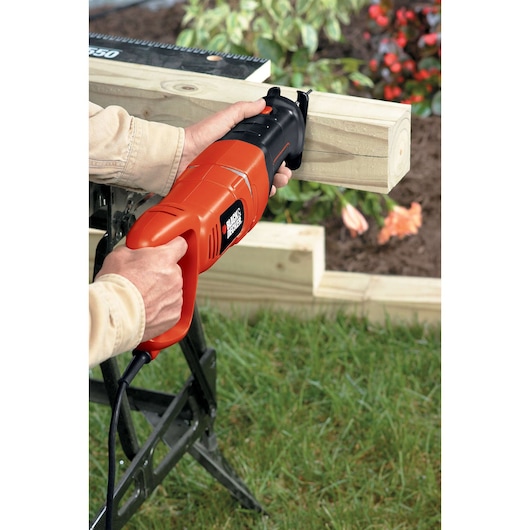 BLACKDECKER RS500 scie sabre coupant du bois à l'extérieur, outil orange et noir tenu à la main.