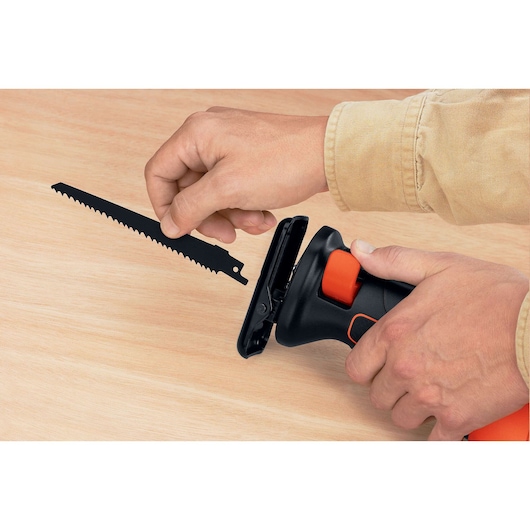 Photo de la scie sabre BLACKDECKER RS500 équipée d'une lame, vue rapprochée sur une surface en bois.