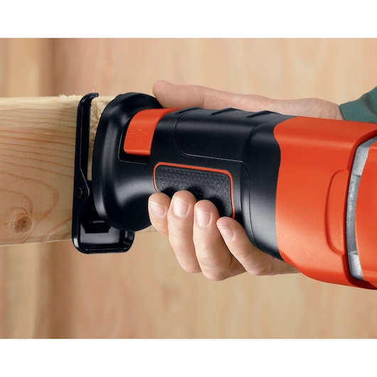 Photo de la scie sauteuse BLACKDECKER RS500 coupant du bois, gros plan sur la poignée et la lame.